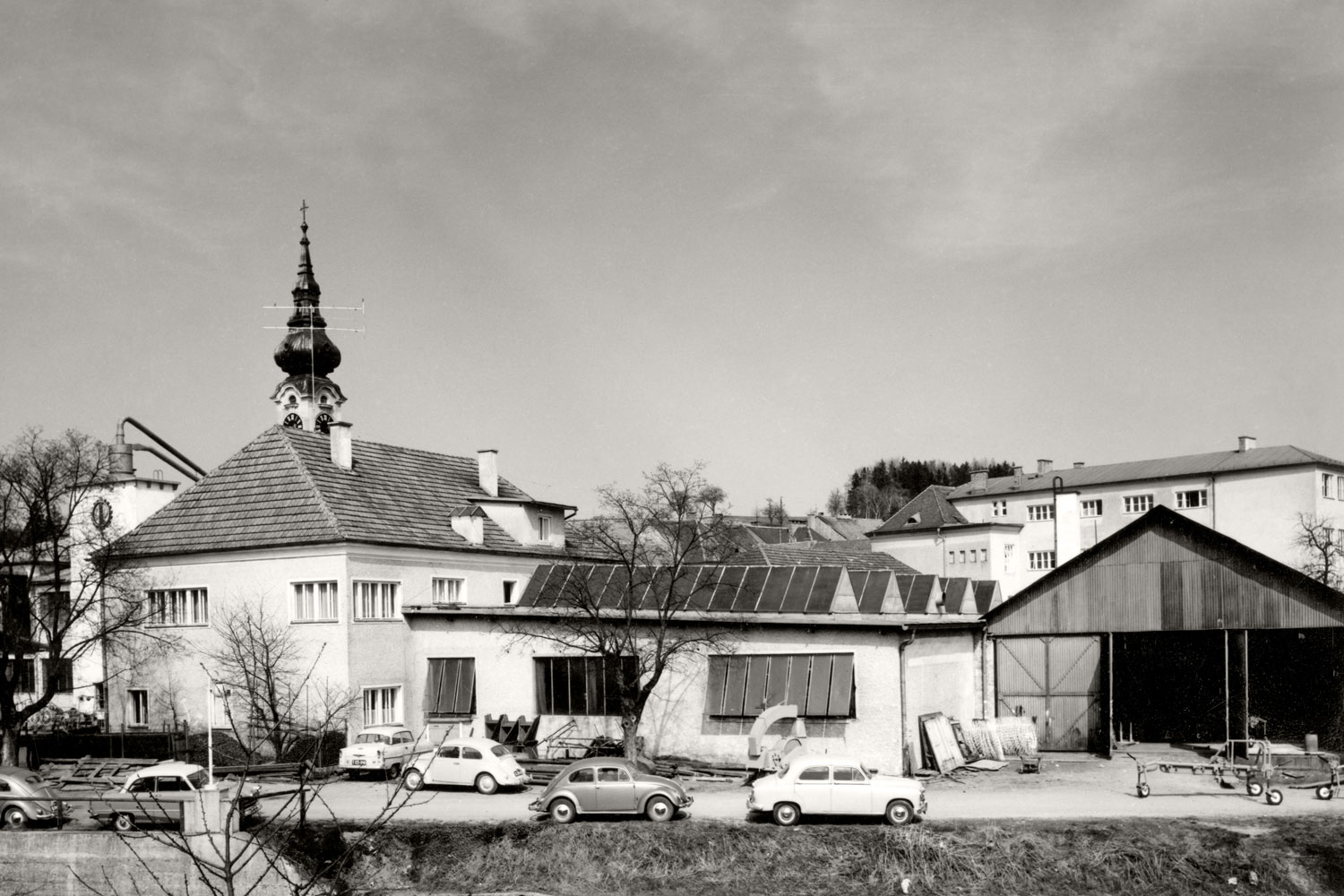 Část centra Grieskirchenu: Závod I firmy PÖTTINGER kolem roku 1960. VW Brouk se těší mezi zaměstnanci/zaměstnankyně firmy PÖTTINGER zjevné oblibě.