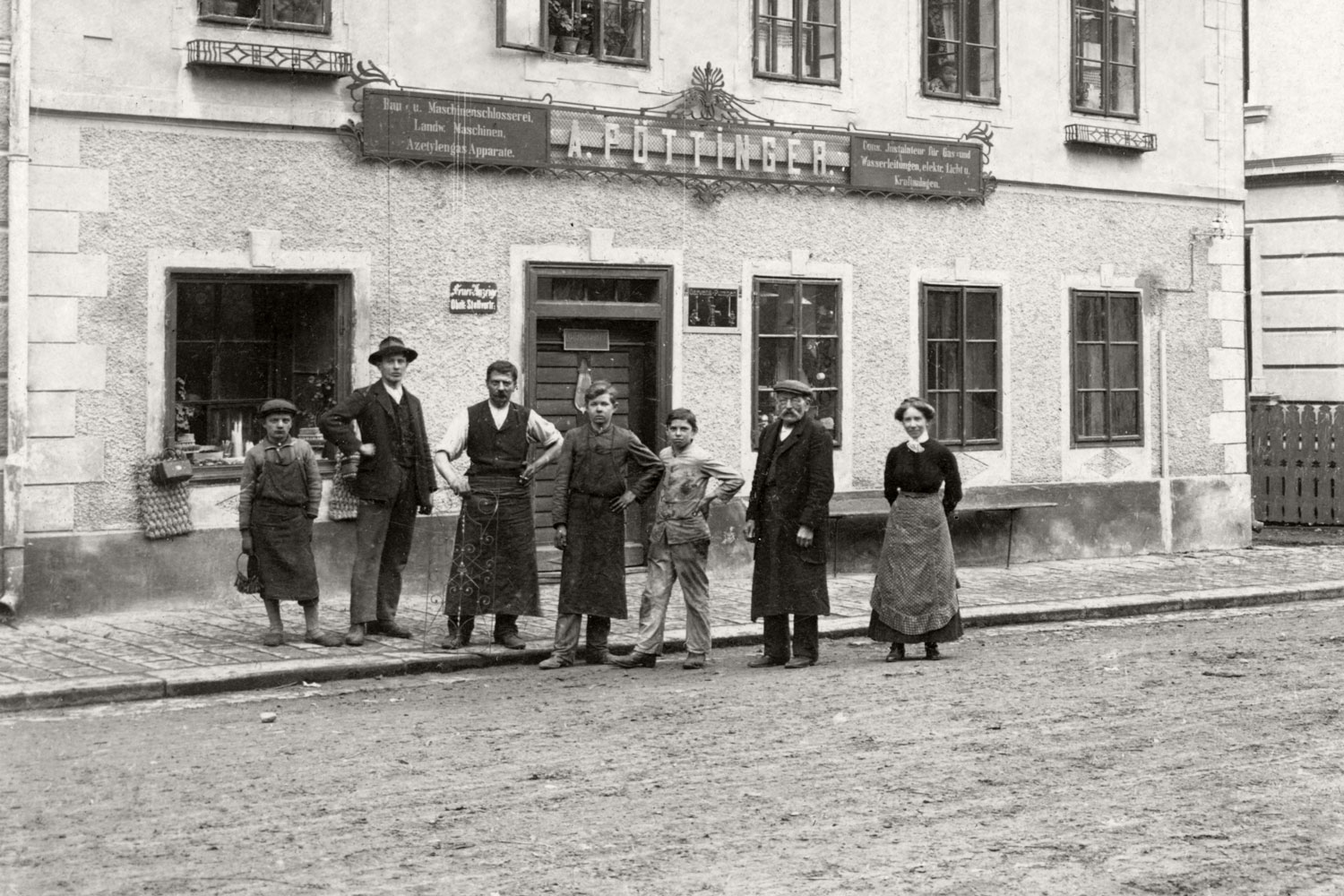 Pöttingerien koti Roßmarktilla päiväämättömässä valokuvassa. Yrityksen nimikyltti valaisee sitä, miten monipuolisia palveluita se tarjosi.