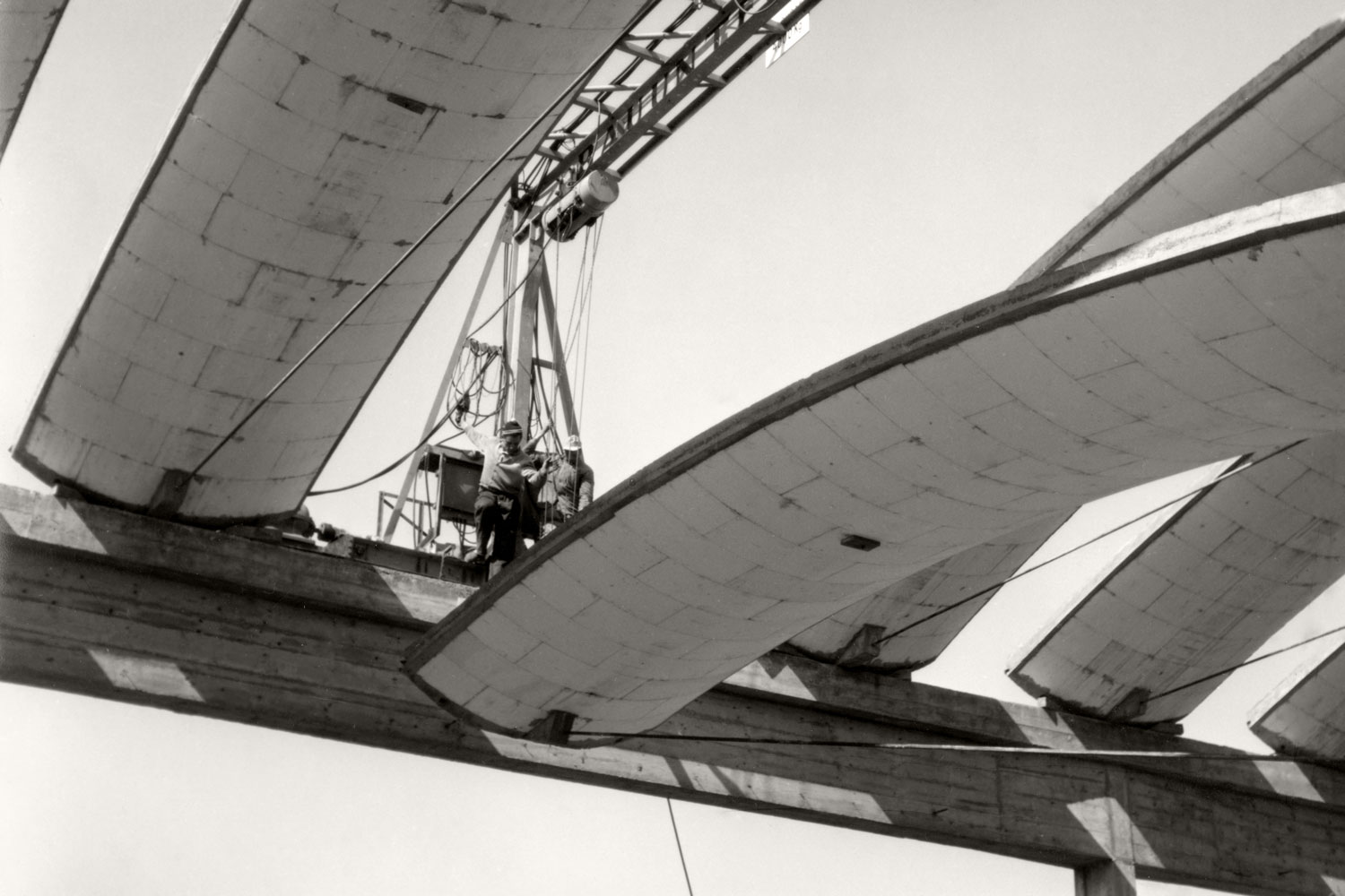 Hallenbau im neuen Werk: Ein Kran hebt eines der konvexen Elemente auf Dachstuhlhöhe.