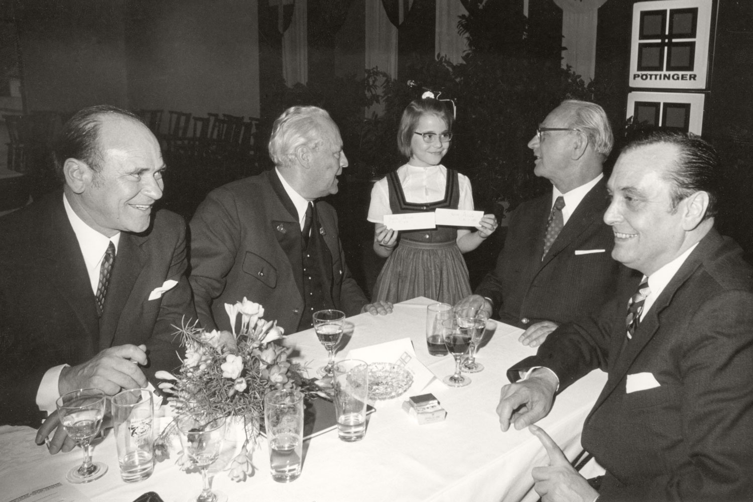 De aandacht van bondspresident Franz Jonas (tweede van rechts) gaat geheel naar de kleine dame aan tafel.