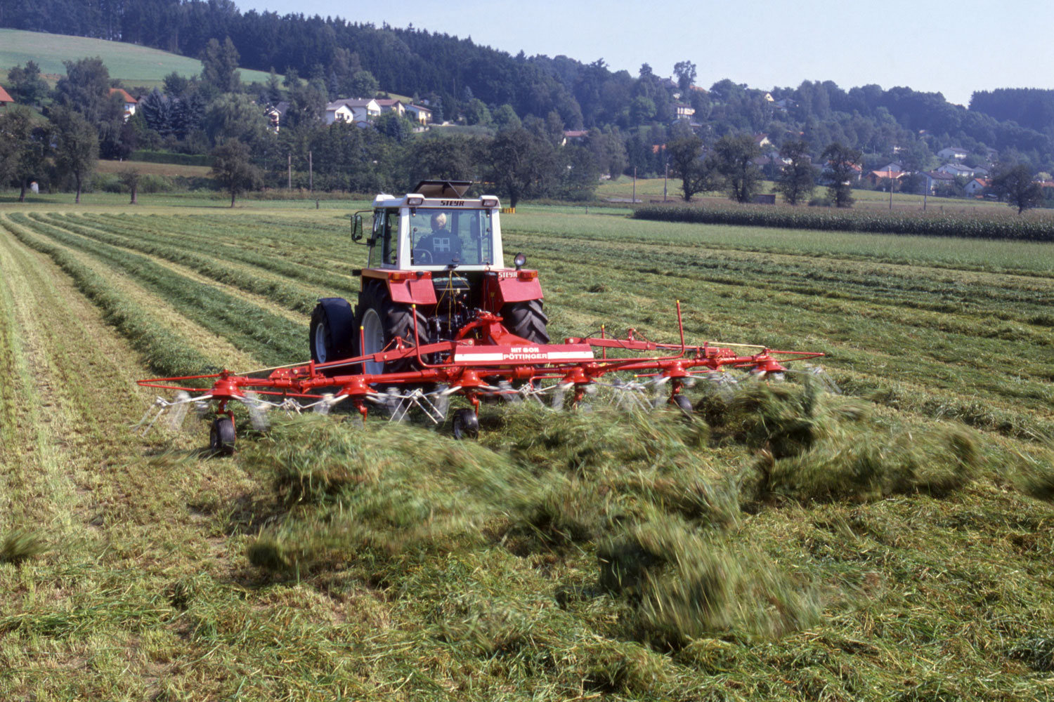 Ein vertrautes Bild mit dem Aroma von frischem Heu: Heuwenden mit einem HIT Zettkreisel von PÖTTINGER.