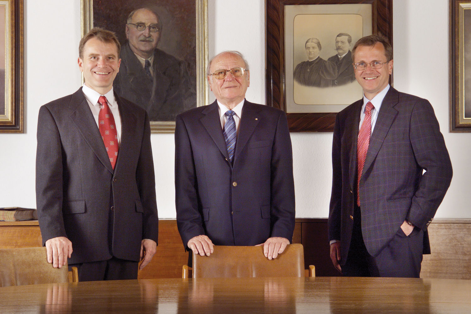 One photo, four generations: Heinz Pöttinger senior with his sons Klaus (left) and Heinz (right). In the background an oil painting of Alois and the historical photo of the married couple Juliane and Franz Pöttinger.